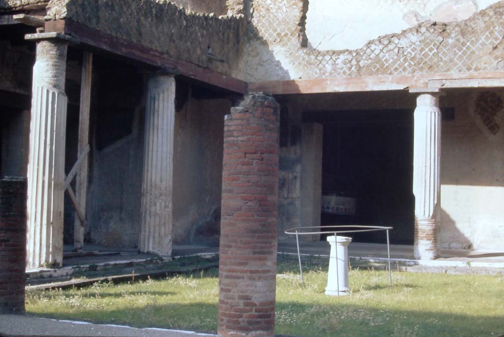 VI.13 Herculaneum. 4th December 1971. Peristyle 13.
Looking towards south-west corner of peristyle, with doorway to the large oecus, the Salon Nero, centre right.
Photo courtesy of Rick Bauer, from Dr George Fay’s slides collection.
