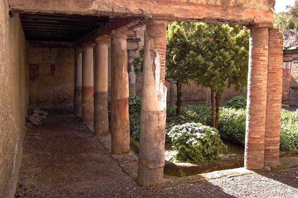 VI.17, Herculaneum. April 2002. Looking across peristyle from north-east. Photo courtesy of Nicolas Monteix.
The peristyle was bordered by Tuscan columns made of brick but covered with stucco.
The lower part of the columns were painted in black and red alternatively.
