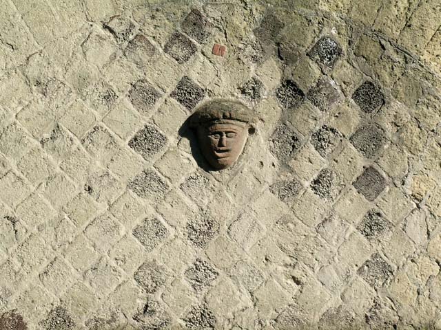 VI.29, Herculaneum. May 2006. Detail of terracotta mask set in brickwork above doorway. Photo courtesy of Nicolas Monteix