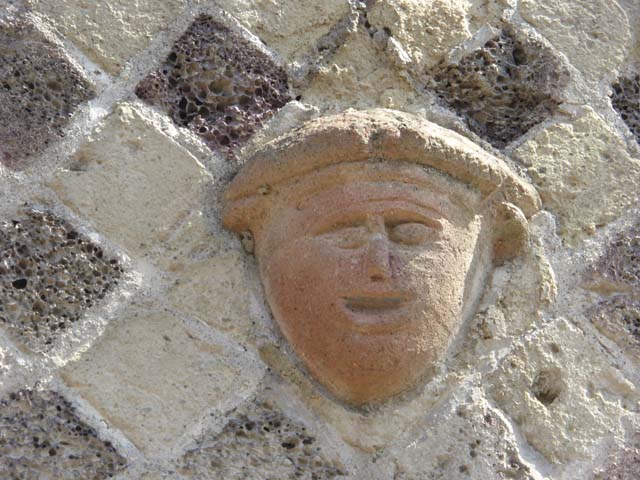 VI 29, Herculaneum, July 2015. Detail of terracotta mask above doorway. Photo courtesy of Michael Binns.
