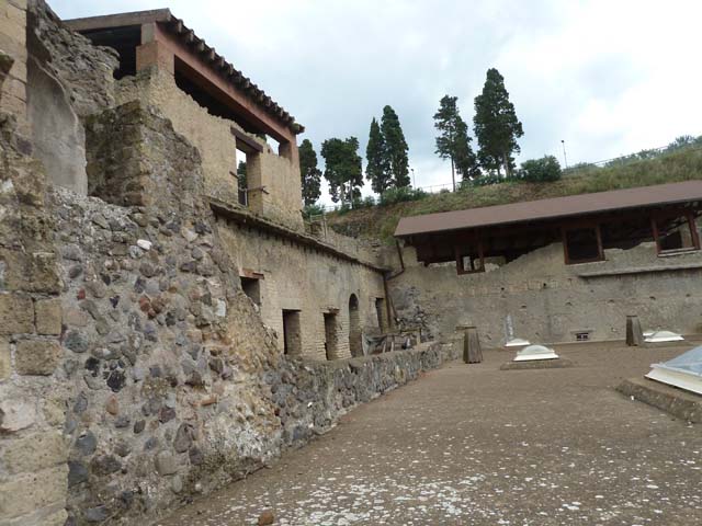 Ins. Orientalis I, 1a, Herculaneum, September 2015. Looking east along roof of Suburban baths.  On the left of it are the lower floor rooms that used to be connected to the House of the Gems, until the stairs were taken away, and it became a separate dwelling. It is known as the House of M. Pilius Primigenius Granianus due to a bronze seal being found in a carbonised wooden box.

