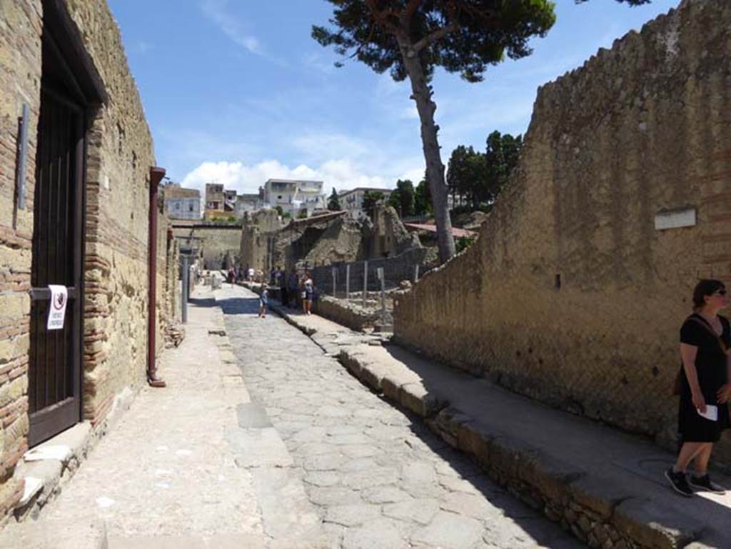 Ins. Orientalis I, 2, on right, Herculaneum, July 2015. Looking north along Cardo V. Inferiore, with frontage on north side of entrance doorway, on right. In the centre of the photo is the entrance to the stable area, with the ramp in the pavement. Photo courtesy of Michael Binns.
