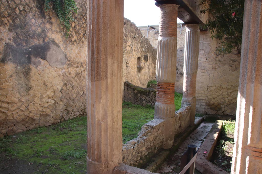 V.15 Herculaneum. October 2022.
Looking south across east portico towards kitchen area, with niche visible in east wall. Photo courtesy of Klaus Heese.
