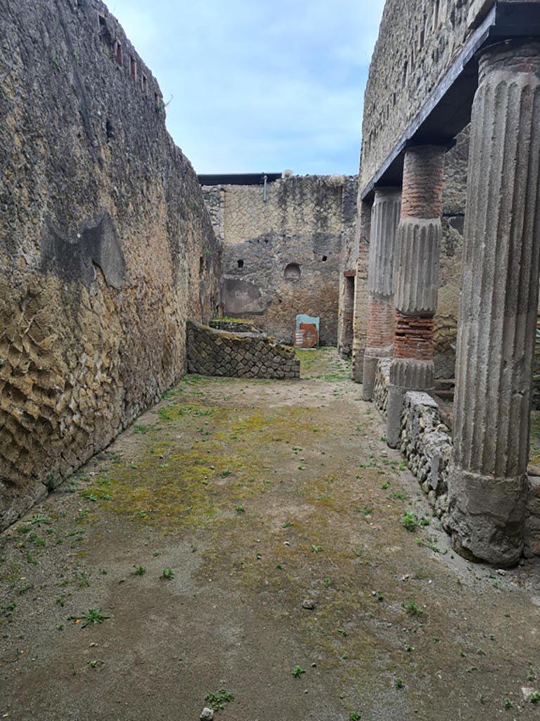 V.15 Herculaneum. May 2024. 
Looking south along east portico towards south wall of kitchen with niche. Photo courtesy of Klaus Heese.
