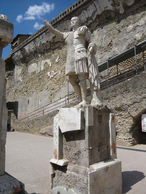 Herculaneum, August 2013. Statue of Marcus Nonius Balbus. Photo courtesy of Buzz Ferebee. 
Parts of the marble statue (its head, left foot and part of the base) were found in 1942 on the terrace outside the Baths, but the left side of the statue’s body and other fragments were only discovered in 1981 on the beach underneath the terrace.
See Cooley, A. and M.G.L., 2014. Pompeii and Herculaneum: A Sourcebook. London: Routledge, F105b, p. 191.

