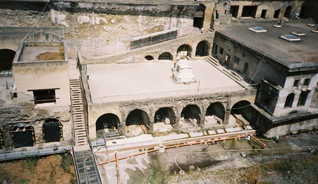 Herculaneum, May 2006. Looking north-east from roadway towards Suburban Baths, centre, and House of the Telephus Relief, top right with scaffolding. Above the roof of the baths, the House of the Gems can be seen. The lower floor, with doorways onto a loggia, belonged to the House of M. Pilius Primigenius Granianus.
