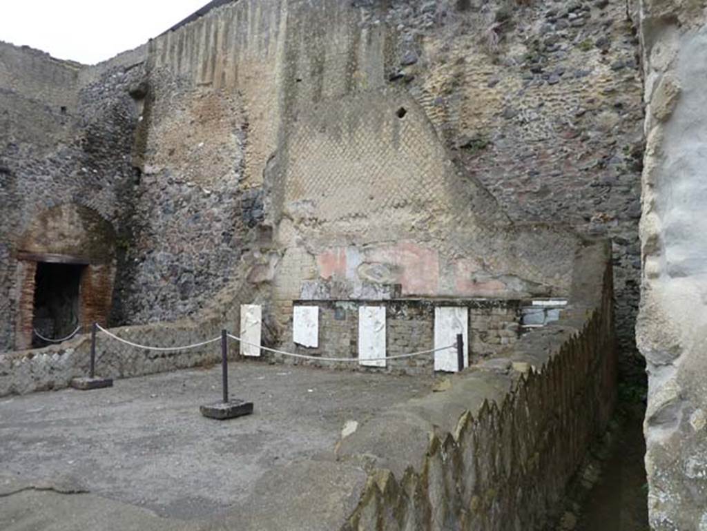 Herculaneum, September 2015. Sacred Area terrace, looking north in the shrine of the Four Gods. The copies of the reliefs are thought to be hanging in their original position, fastened to the front wall of the podium.  The originals, now in Naples Museum, were recently found on the ancient beachfront, no doubt thrown there by the force of the eruption, and show Minerva, Neptune, Mercury and Vulcan.
