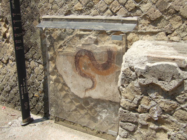 Cardo IV, west side, Herculaneum. May 2006. Remains of painted serpent on south side of street altar. 