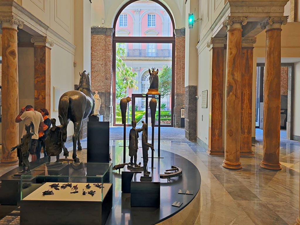 Herculaneum, April 2023. Bronzes in “Campania Romana” gallery in Naples Archaeological Museum. 
Looking towards glass case with the small bronze chariot attachments. Photo courtesy of Giuseppe Ciaramella.
