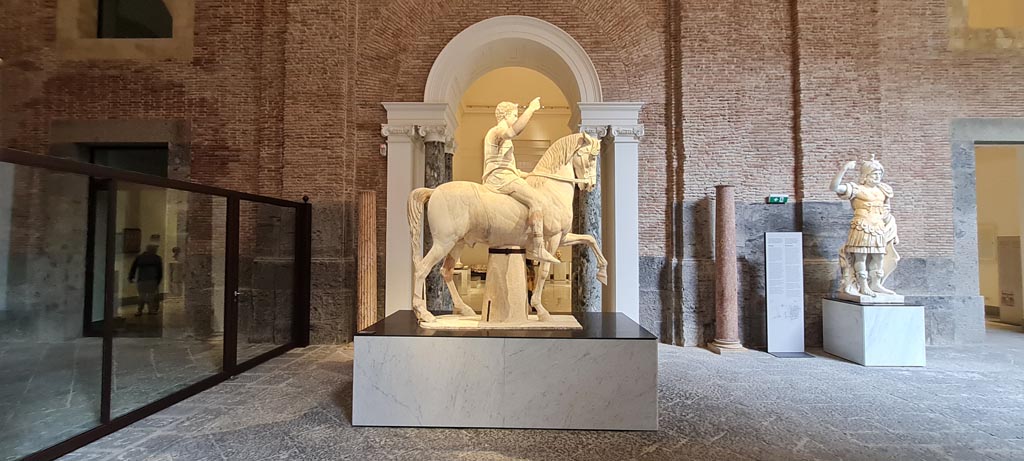 Herculaneum, public area. April 2023. 
White marble statue of Marcus Nonius Balbus, (inv.6014) in centre, and white marble statue of Mars Ultor (Mars the Avenger), on right.
On display in “Campania Romana” gallery of Naples Archaeological Museum.  Photo courtesy of Giuseppe Ciaramella.
