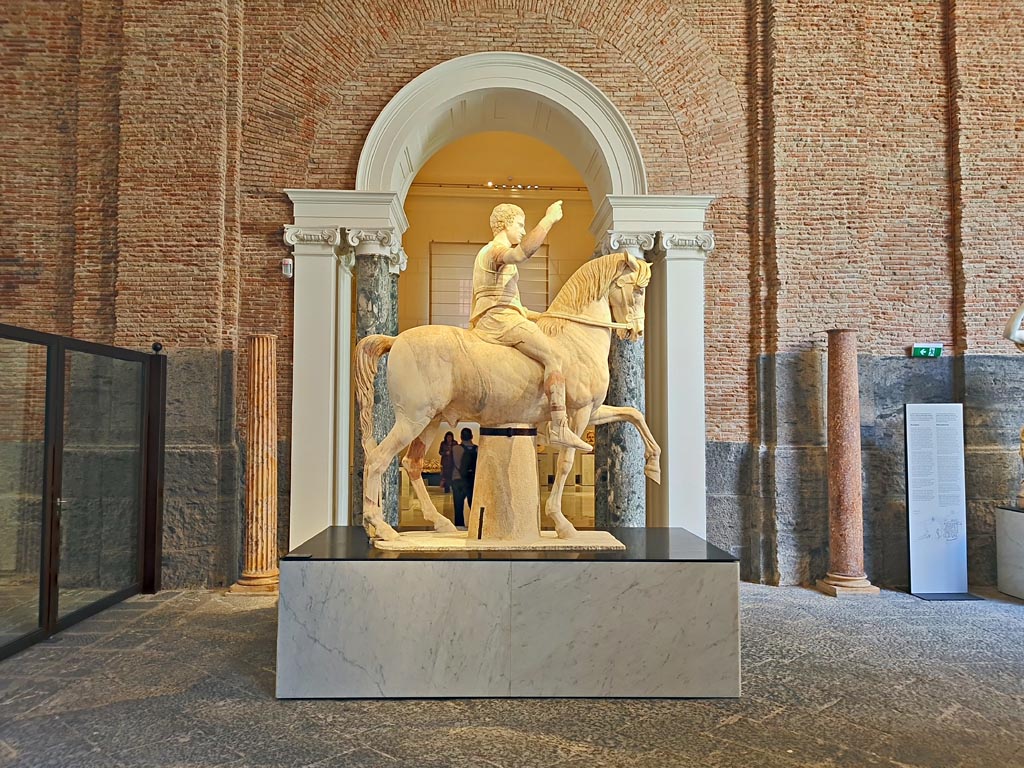Herculaneum, public area. April 2023. 
White marble statue of Marcus Nonius Balbus, side view, on display in “Campania Romana” gallery of Naples Archaeological Museum. inv. 6014.  
Photo courtesy of Giuseppe Ciaramella.
