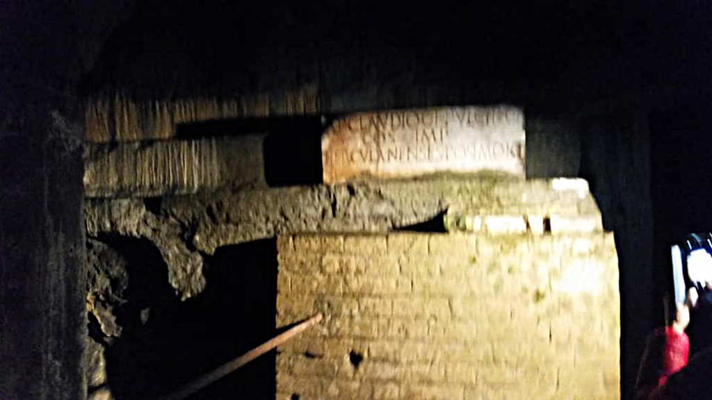 Herculaneum Theatre, photo taken between October 2014 and November 2019. 
Copy of inscription to AP Claudio C F Pulchro after his death, in situ underground. Photo courtesy of Giuseppe Ciaramella.
