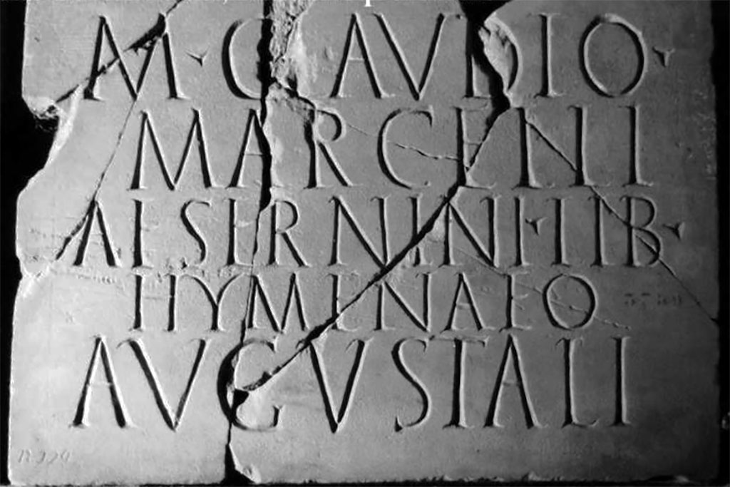 Herculaneum funerary plaque to Marcus Claudius Marcellus Aeserninus Lib Hymenaeus.
Found 6th of August 1748. Exact find location unknown.

According to the Epigraphic Database Roma this reads
M(arco) Claudio 
Marcelli
Aesernini lib(erto) 
Hymenaeo, 
Augustali.      [CIL X, 1448]

Now in Naples Archaeological Museum. Inventory number 3759.
