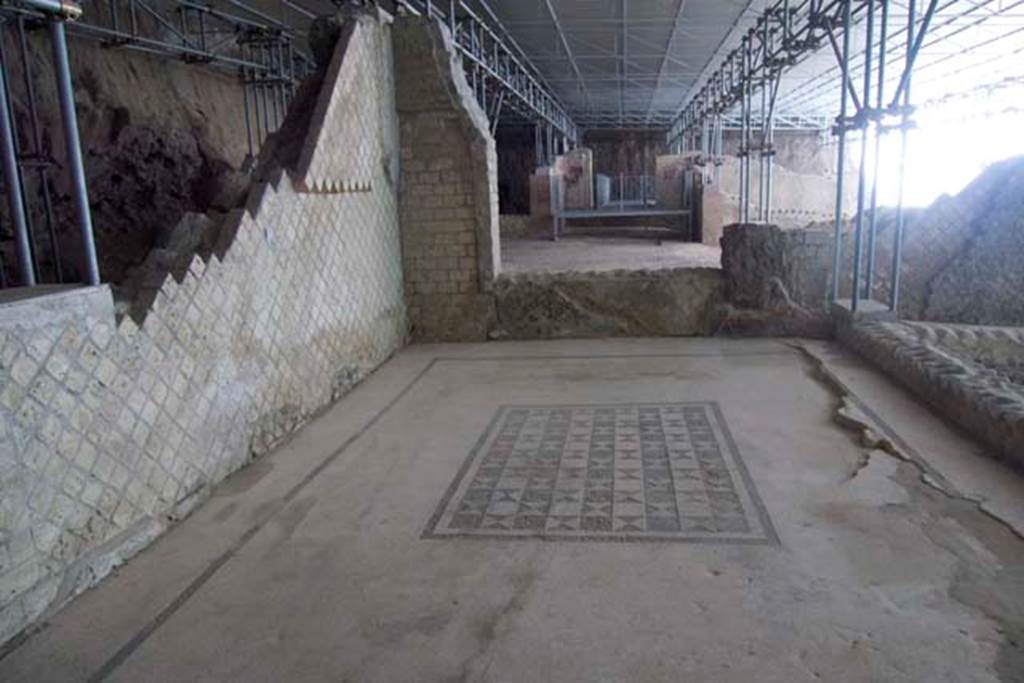 Villa dei Papiri, Herculaneum. July 2010. 
Looking east across room (r), at the rear of room (s), on right. Photo courtesy of Michael Binns.
According to Guidobaldi and Esposito, a limited excavation survey was carried out in room (s) to verify the presence of the pavement. 
The survey, carried out along the east wall, confirmed that the pavement of the room, in opus tessellatum, must have rested upon a flat floor supported by wooden beams, which collapsed at the time of the 79 C.E. eruption.
It is probable, therefore, that the floor is still in situ, but subsided under several dozens of centimetres of collapsed material.
See Esposito D. and Guidobaldi M., 2010. New Archaeological Research at the Villa of the Papyri, in the Villa of the Papyri at Herculaneum. Berlin: De Gruyter, p. 28, notes 14 and 15. 
