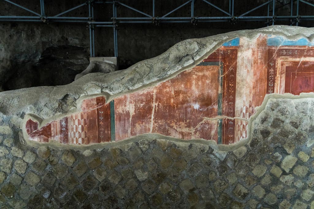 Herculaneum Villa dei Papiri. October 2023. 
Room (e), east ala, remaining painted decoration on north wall at west end. Photo courtesy of Johannes Eber. 
