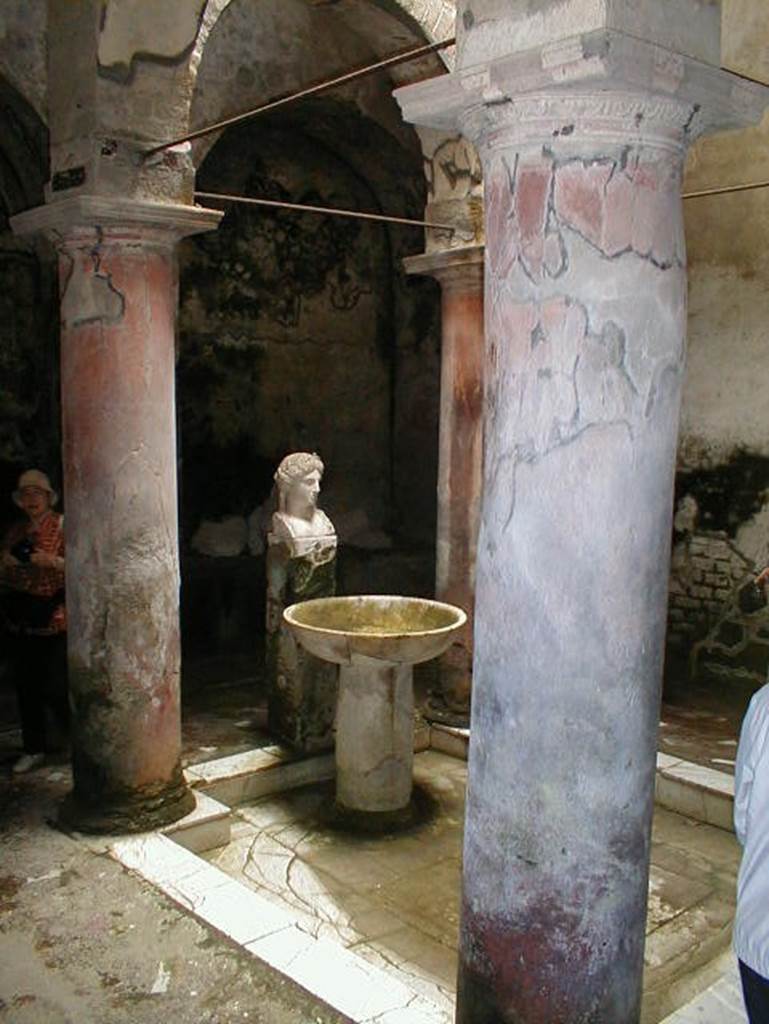 Fountain bust of Apollo, Suburban baths, Herculaneum. May 2004. Atrium with fountain bust of Apollo.
The four columns were originally painted red.

