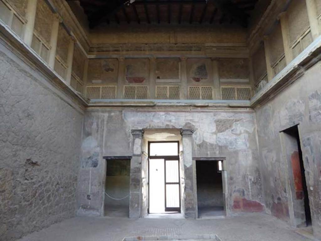 V.1, Herculaneum, October 2014. Looking west in atrium. West wall of atrium, with doorways to room 3, on left, the entrance corridor and room 2, on right. The upper floor is decorated as a false loggia. Photo courtesy of Michael Binns.