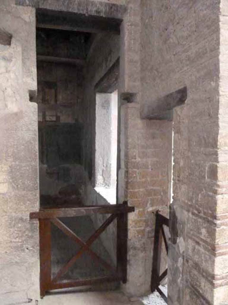 V.1 Herculaneum. May 2010. Room 8 in north-east corner of atrium. Two doorways, on left one into room 7, the other from room 6, on the right.